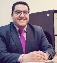 Lu'ay Al-Hasasnah smiling sat at a desk